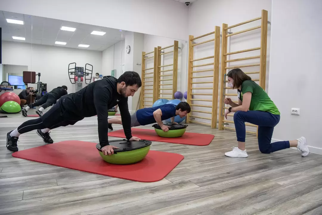 Rehabilitation therapist conducts exercise therapy session for patients with low back pain